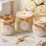 Lumânări parfumate elegante, ambalate cu fundițe aurii, alături de flori albe, cristale și bilețel scris de mână – o compoziție rafinată perfectă pentru idei de cadouri magice, feminine și luminoase, potrivite pentru orice ocazie specială