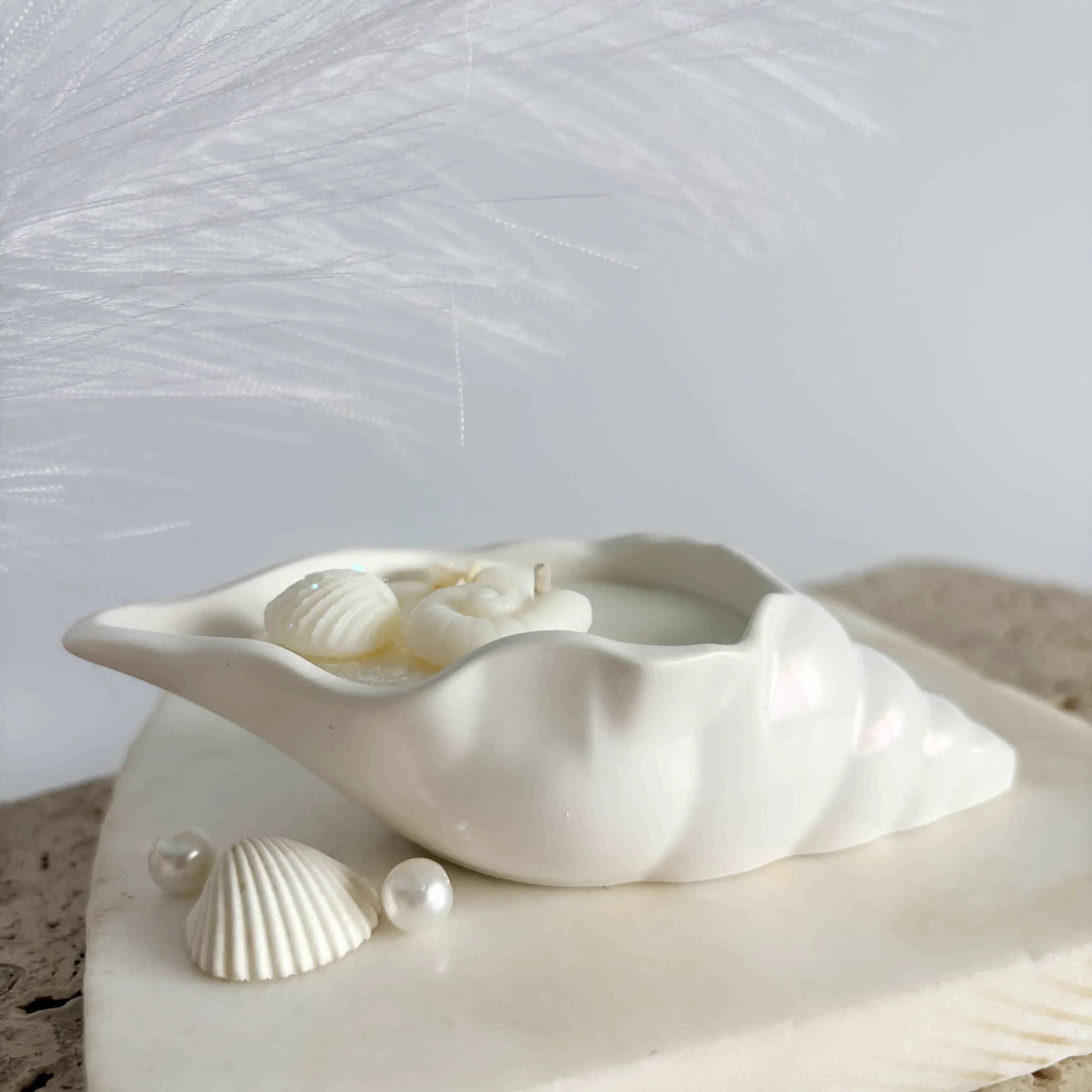 Vedere laterală lumânare în vas ceramic în formă de scoică Perlina, cu decorațiuni marine