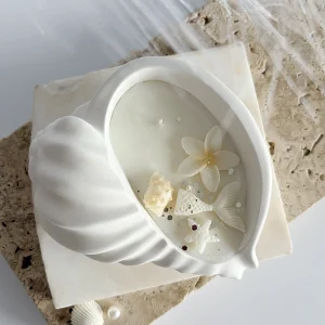 Lumânare parfumată în vas din praf ceramic în formă de scoică cu decorațiuni marine