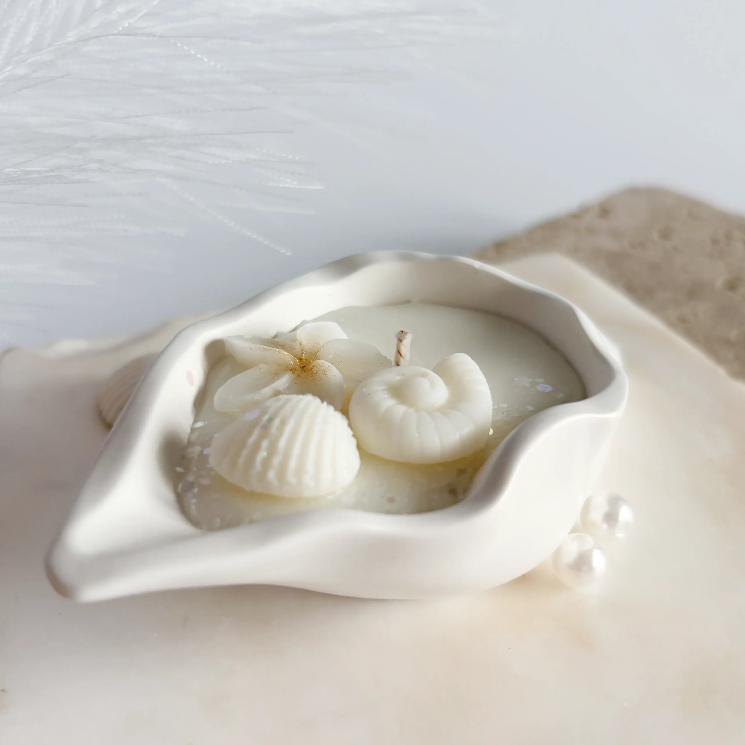 Fotografie din spate a vasului ceramic în formă de scoică alungită al lumânării artizanale Perlina